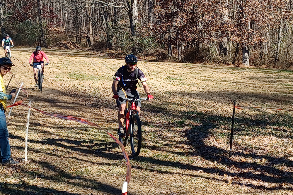 Lead cyclist racing downhill on mountain bike trail